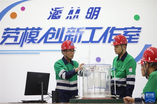 在甘肃省金昌市金川区，金川集团铜业有限公司贵金属冶炼分厂提纯工序工序长潘从明（左）在工作室给新员工讲授创新模型（2022年9月21日摄）。新华社记者 马希平 摄