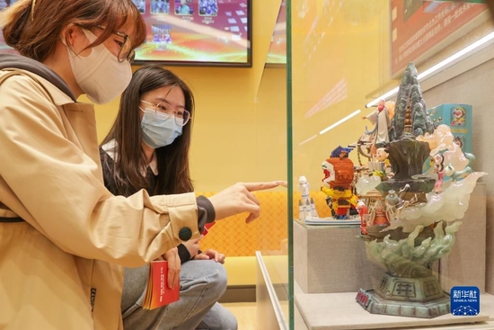 10月10日，观众在“奋进新时代”主题成就展第五单元“坚定文化自信 建设社会主义文化强国”展厅内观看电影相关的文化产品。新华社记者 张玉薇 摄