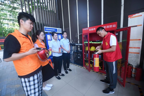 杭州市临安区锦南街道的消防安全员（右一）在社区微型消防站给该片区的网格员进行消防器材使用培训（2022年6月23日摄）。新华社记者 徐昱 摄