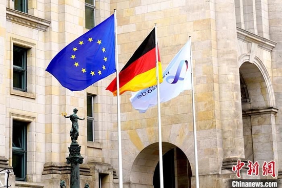 资料图：当地时间2020年7月1日，德国柏林，德国国会大厦前从左到右依次挂出代表欧盟、德国和德国担任欧盟轮值主席国的三面旗帜。 中新社记者 彭大伟 摄