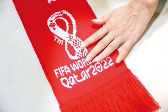 11月5日，浙江杭州市一家企业的工人在整理2022卡塔尔足球世界杯球迷围巾。2022年卡塔尔足球世界杯开赛前，该家企业生产的30余万条世界杯球迷围巾和10余万顶球迷帽子已全部发往海外订货商。图/中新