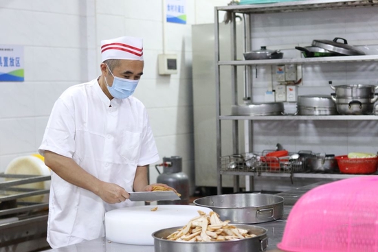  张容华在广深珠高速公路有限公司的食堂切菜。受访者供图
