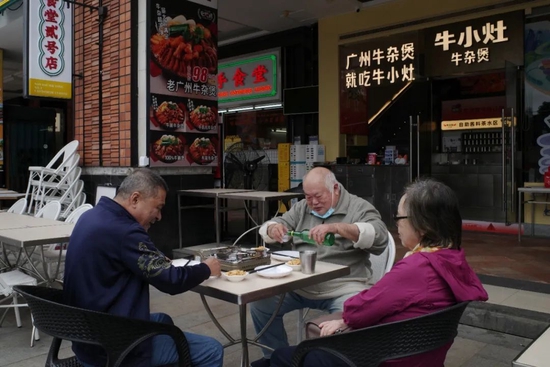 12月1日，广州市海珠区，市民在客村地铁站附近一店铺吃午餐。