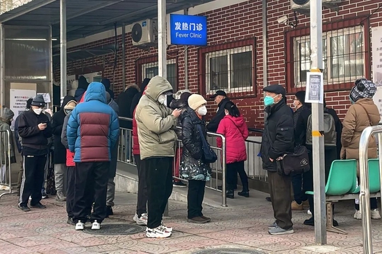  2022年12月14日，北京，在新冠疫情期间，人们在一家发烧诊所外排队。（图|人民视觉）