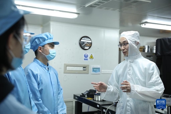 国防科技大学前沿交叉学科学院研究员周朴（右）与学生交流讨论（2022年5月16日摄）。国防科技大学前沿交叉学科学院研究员周朴带着课题组成员经过一段时间的“闭关”试验，他们的研究成果“低量子亏损光纤激光器”再次实现突破。新华社发（杨阳 摄）