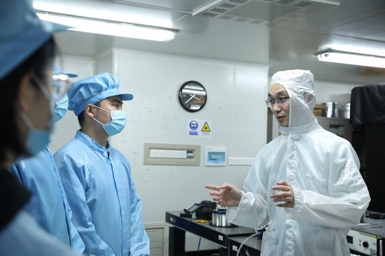 国防科技大学前沿交叉学科学院研究员周朴(右)与学生交流讨论(2022年5月16日摄)。国防科技大学前沿交叉学科学院研究员周朴带着课题组成员经过一段时间的“闭关”试验,他们的研究成果“低量子亏损光纤激光器”再次实现突破。新华社发(杨阳 摄)