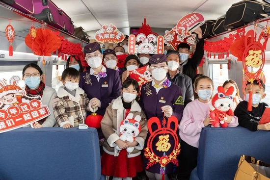  2023年1月7日春运启动。这是当日旅客和乘务员在G1373次列车上拿着新年装饰品合影留念。新华社记者 王翔 摄