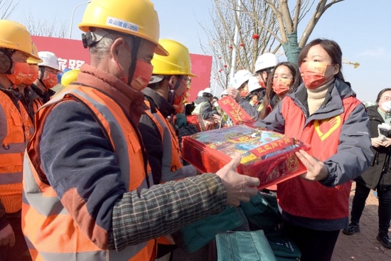 1月16日，合肥志愿者为即将返乡的中建四局六公司的工人发放年货礼包。 新华社发