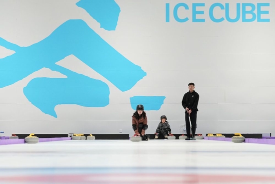  2023年2月1日，游客在北京国家游泳中心“冰立方”内体验冰壶。新华社记者 鞠焕宗 摄