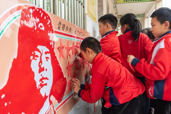 △2022年3月3日，江西省吉安市新干县实验小学的少先队员将心里话贴在“雷锋叔叔，我想对您说……”的倡议海报上。