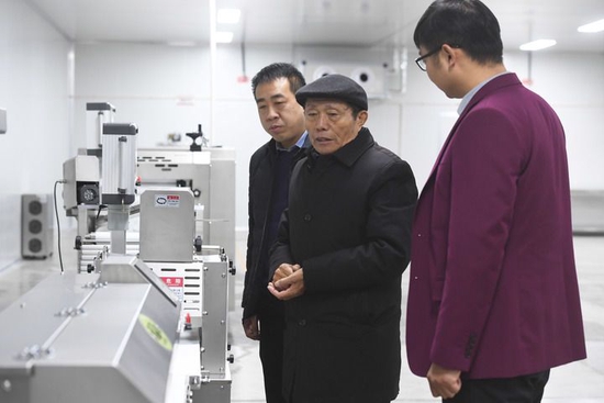 2月21日，在位于河南省濮阳市庆祖镇西辛庄村的食品工业园，李连成（中）查看即将投产的馒头生产线。新华社记者 张浩然 摄