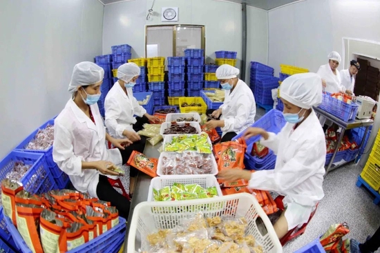  △在广西柳州一螺蛳粉生产企业的生产车间，工人进行标准化作业。