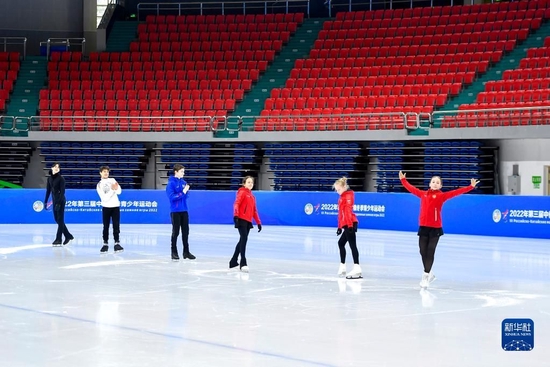 在长春五环体育馆，参加第三届中俄冬季青少年运动会的俄罗斯花样滑冰运动员在赛前场地适应性训练时向场边的中国运动员致意（2022年12月15日摄）。新华社记者 许畅 摄