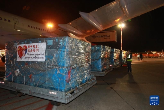 在塞尔维亚首都贝尔格莱德，写有 “铁杆朋友，风雨同行”字样的中方捐赠医疗物资从飞机上卸下（2020年3月21日摄）。新华社记者 石中玉 摄