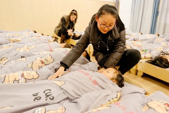 ▲ 老师照顾正在午睡的孩子们。图 / 视觉中国