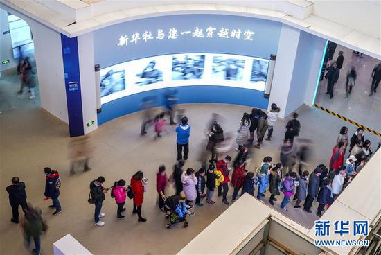 11月24日，观众在“伟大的变革——庆祝改革开放40周年大型展览”新华社“追光忆影”展项前参观。新华社记者 殷刚 摄