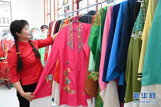 　　在河南省信阳市光山县文殊乡东岳村文化接待中心，光山花鼓戏传承人张秀芳在展示花鼓戏服装（6月6日摄）。新华社记者 张浩然 摄