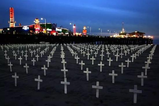  图为2007年11月25日，在美国加利福尼亚州圣莫尼卡海滨，人们在沙滩上竖起十字架，纪念在伊拉克战争中死亡的美军士兵。图源：新华网