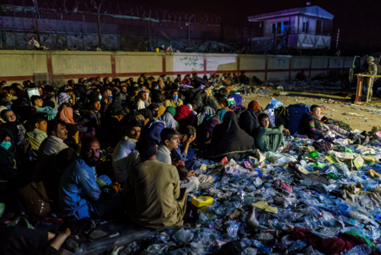  ▲英国士兵抵达爆炸现场维持治安后，阿富汗难民们围聚在一旁。来源：IC Photo
