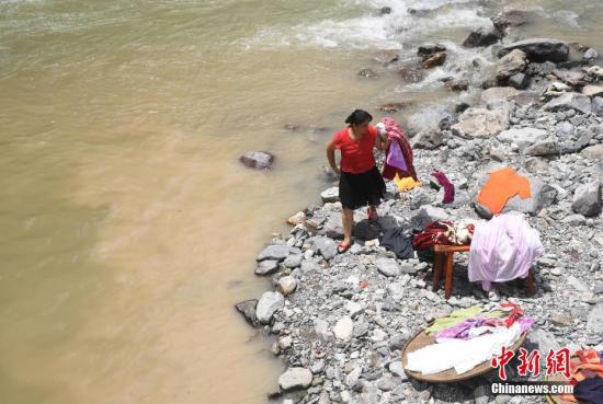 一位村民在河边洗晒衣物。中新社记者 王刚 摄
