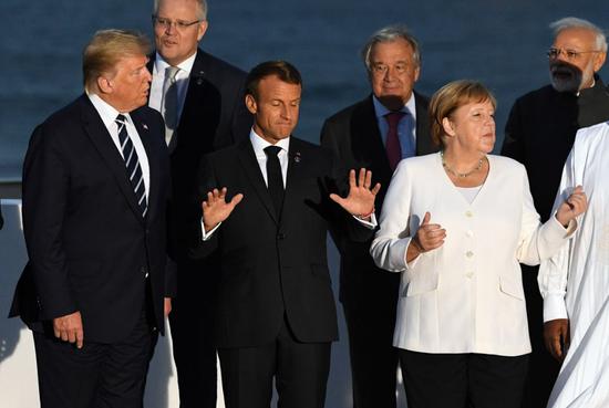 8月25日，在法国比亚里茨，法国总统马克龙、美国总统特朗普、德国总理默克尔参加合影。新华社/路透