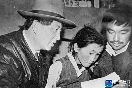 在西藏工作期间，孔繁森（左）在辅导藏族儿童读书（资料照片）。新华社发