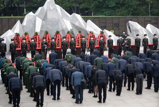  安葬仪式现场，全体人员向中国人民志愿军烈士遗骸三鞠躬。陶冉 摄