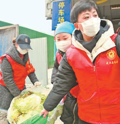 2月27日，潘丽娟（右一）在社区为居民送爱心菜。本报记者 张武军摄