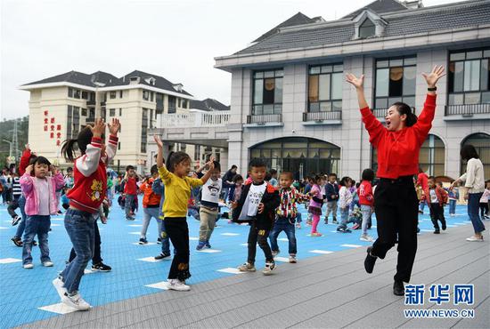 在贵州省正安县瑞濠易地扶贫搬迁安置点的一所幼儿园，老师与孩子们在课间活动（2019年10月11日摄）。新华社记者 杨文斌 摄