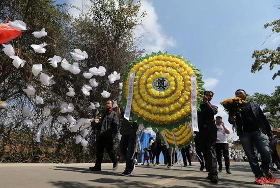 ▲各界群众到西昌市殡仪馆悼念，朵朵白花布满路旁