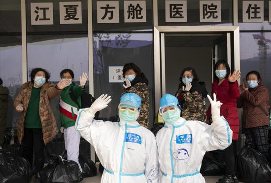 新冠肺炎患者治愈后走出舱与医护人员合影。摄/新京报记者 陶冉