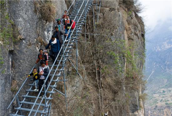 “悬崖村”村民沿着钢梯下山，准备搬进新家（5月13日摄）。新华社记者 江宏景 摄