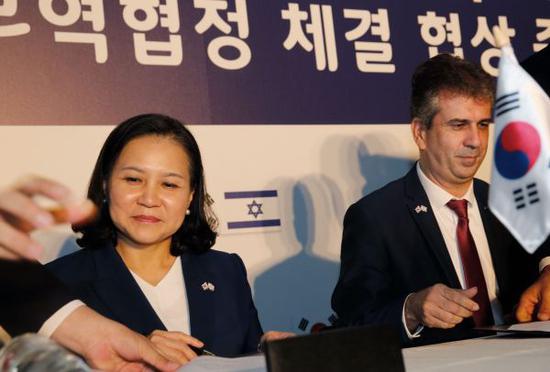 8月21日，韩国产业通商资源部通商交涉本部长俞明希（左）与以色列经济和工业部长埃利·科亨签署协定。（新华社/法新）
