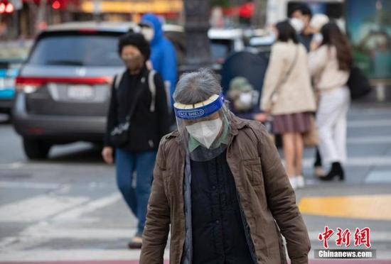 资料图：当地时间11月21日，美国加州旧金山市民戴口罩出行。 中新社记者 刘关关 摄