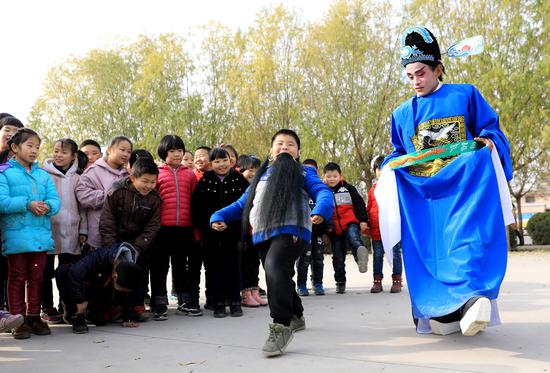 ↑在河北省晋州市李家庄小学，非遗“李家庄咳嗨腔”表演队队员与小朋友互动（2018年11月28日摄）。新华社记者 赵丹惠 摄