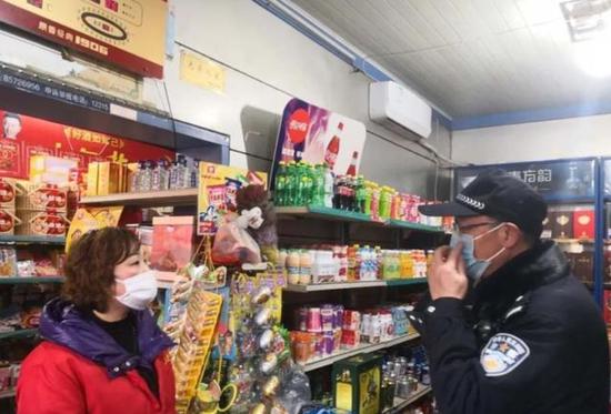  图为民警提醒超市业主正确佩戴口罩。（图源：南昌网警）