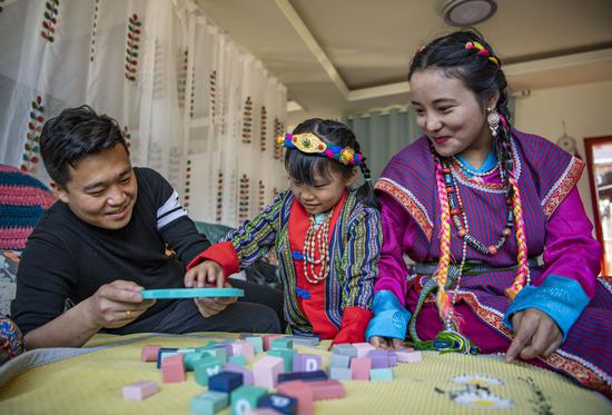 ↑2021年2月11日，在位于西藏林芝市墨脱县的家中，山西小伙张淳焕和门巴族妻子扎西玉珍陪女儿玩积木。