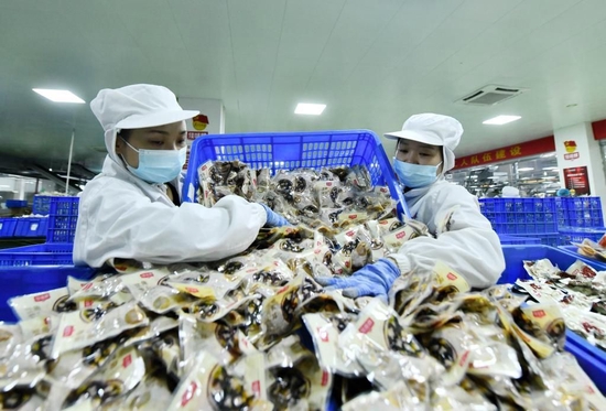△2023年2月8日，工人在柳州螺蛳粉生产集聚区一生产车间包装产品。