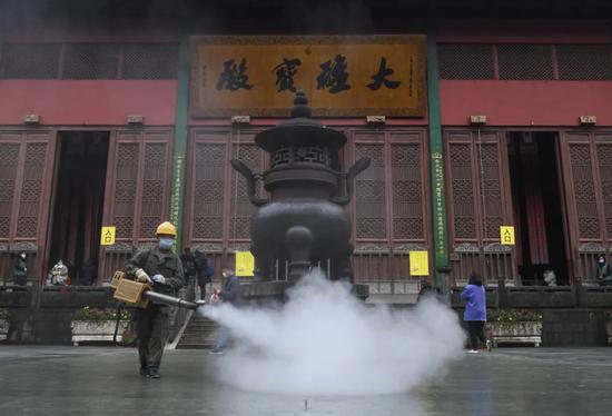 12月26日，工作人员在浙江杭州灵隐寺大雄宝殿前进行消杀。