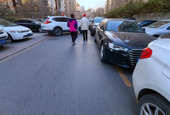 小区东三门附近私家车“踩着”消防通道标志线停放