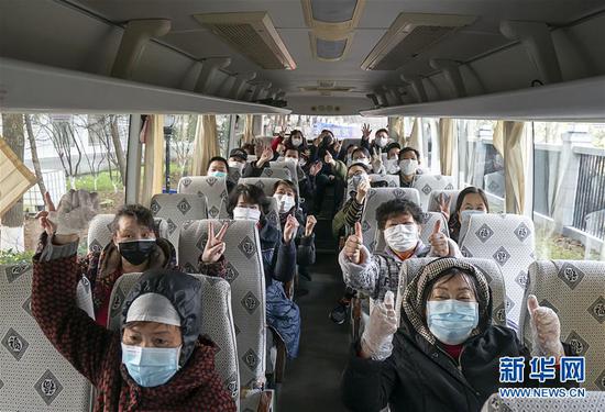 　　3月10日，在湖北武汉，解除隔离的治愈患者在上车后比出了胜利的手势。 新华社记者 熊琦 摄