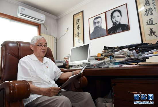 6月12日，李宏塔在家中书房读书，墙上挂着祖父李大钊和祖母赵纫兰的相片。新华社记者 周牧 摄