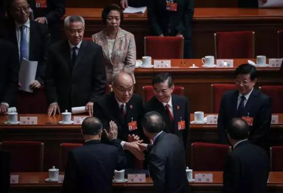 两会照片:2019两会现场照片精选 周强张军与人握手打招呼 3月12日,北京人民大会堂,十三届全国人大二次会议第三次全体会议后。当日,最高人民法院院长周强(中排左二)和最高人民检察院检察长张军(中排左一)在会上作两高报告。中国青年报·中青在线 中国青年网记者 李峥苨/摄