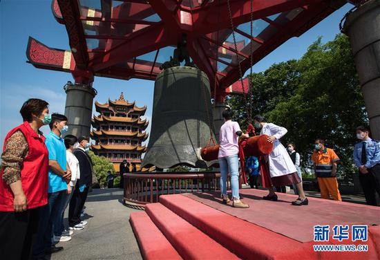 4月29日,武汉黄鹤楼景区重新开放,这是抗疫一线代表在武汉黄鹤楼景区重新开放仪式上撞钟祈福。 新华社记者 肖艺九 摄