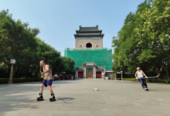2021年8月6日，钟鼓楼文化广场，两位老人在打球，远处是修缮中的钟楼。