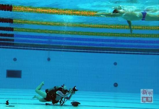 新华社记者丁旭在泳池里使用水下相机拍摄。