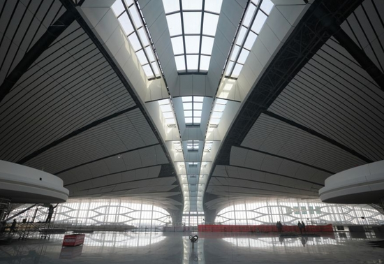 工人在北京大兴国际机场主航站楼内进行装修施工（新华社）
