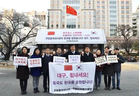  2月27日，在韩国首尔，中国驻韩国大使邢海明（中）与馆员一起为大邱加油。新华社发（中国驻韩国大使馆供图）