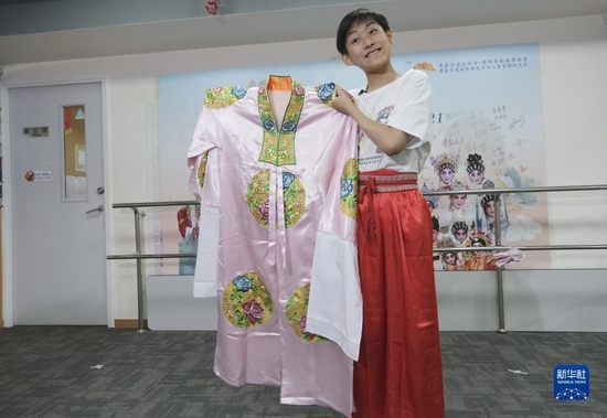 香港粤剧小演员利文喆展示当年给习爷爷表演时穿的戏服，一件粉色底上绣有红蓝色团花的披风（5月29日摄）。 新华社记者 王申 摄