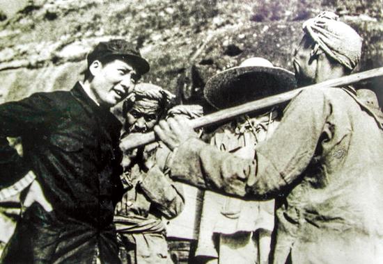  图为毛泽东在延安杨家岭和农民谈话，询问他们的生产和生活情况。 新华社发